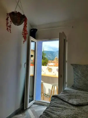a bedroom with a door open to a balcony at Renovated and air-conditioned 2-bedroom apartment with terrace in Saint-Paul-de-Fenouillet