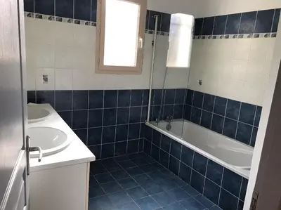a blue tiled bathroom with a tub and a sink at House in a rural village surrounded by vineyards in Leuc