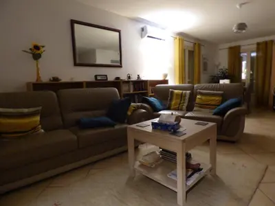 a living room with two couches and a table at House in a rural village surrounded by vineyards in Leuc