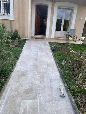 a teddy bear sitting on a sidewalk in front of a house at House in a rural village surrounded by vineyards in Leuc