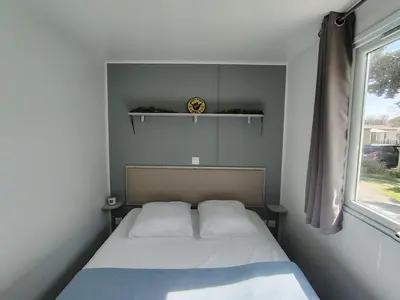 a small bedroom with a bed and a window at Cap du Roc in Port-la-Nouvelle