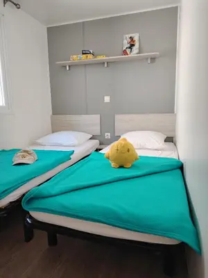 two beds in a room with a stuffed animal on the bed at Cap du Roc in Port-la-Nouvelle