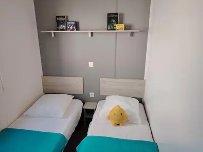 two beds in a small room with a yellow pillow at Cap du Roc in Port-la-Nouvelle