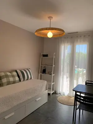 a bedroom with a bed and a table and a lamp at Le chant des cigales in Villemoustaussou