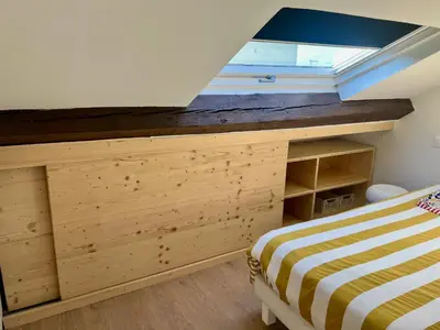 a bedroom with a bed and a skylight at T2 sous les toits, entre gare et centre-ville, Grands buffets in Narbonne