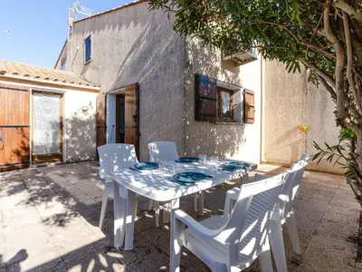 a white table and chairs on a patio at Villa T3 à Gruissan avec climatisation et jardin - FR-1-409A-36 in Gruissan