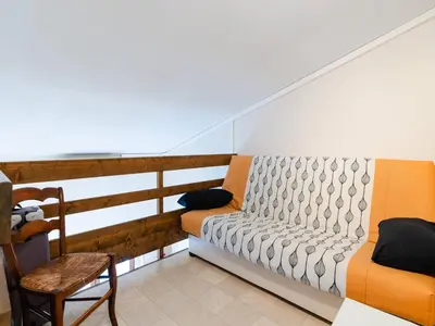 a balcony with a couch and a chair at Villa T3 à Gruissan avec climatisation et jardin - FR-1-409A-36 in Gruissan