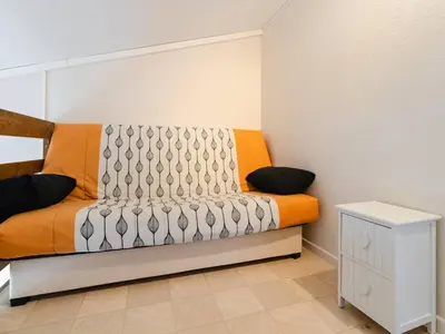 an orange and white bed in a room at Villa T3 à Gruissan avec climatisation et jardin - FR-1-409A-36 in Gruissan