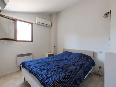 a bedroom with a bed with a blue comforter at Villa T3 à Gruissan avec climatisation et jardin - FR-1-409A-36 in Gruissan