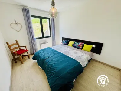 a bedroom with a bed and a chair and a window at Nore & nature in Pradelles-Cabardès