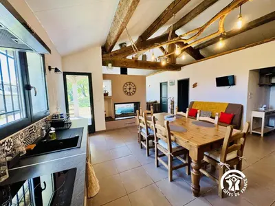 a kitchen and dining room with a wooden table and chairs at Nore & nature in Pradelles-Cabardès