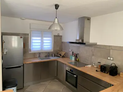 a kitchen with a sink and a refrigerator at La Petite Villa du Soleil in Lavalette