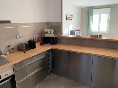 a kitchen with a wooden counter top with a microwave at La Petite Villa du Soleil in Lavalette