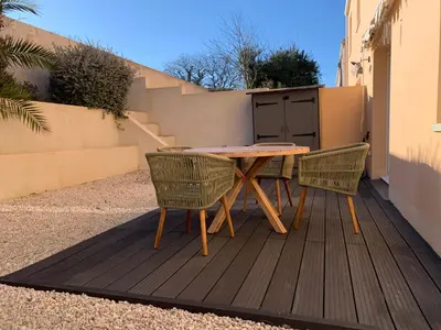 a wooden table and two chairs on a patio at La Petite Villa du Soleil in Lavalette