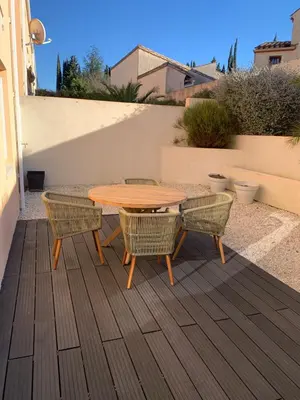 a wooden table and chairs on a patio at La Petite Villa du Soleil in Lavalette