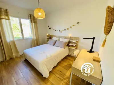 a bedroom with a bed and a table and windows at Le moulin de maquens in Carcassonne