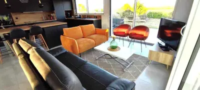 a living room with a couch and orange chairs at Le moulin de maquens in Carcassonne
