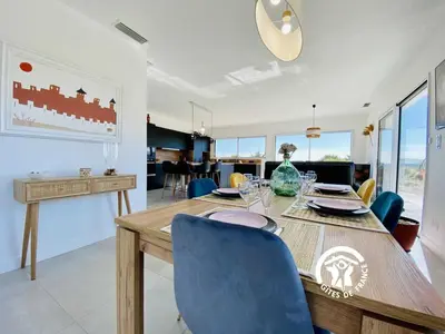 a dining room and living room with a table and chairs at Le moulin de maquens in Carcassonne