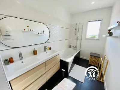a white bathroom with a sink and a mirror at Le moulin de maquens in Carcassonne