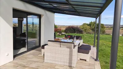 a patio with a table and chairs on a deck at Le moulin de maquens in Carcassonne