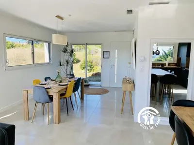 a dining room and living room with a table and chairs at Le moulin de maquens in Carcassonne