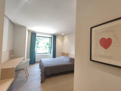 a bedroom with a bed and a painting of a heart at Séjour d'exception au Moulin de la Vernède avec piscine, ruisseau, climatisation et parking in Conques-sur-Orbiel