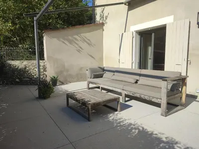 a bench and a coffee table on a patio at Séjour d'exception au Moulin de la Vernède avec piscine, ruisseau, climatisation et parking in Conques-sur-Orbiel
