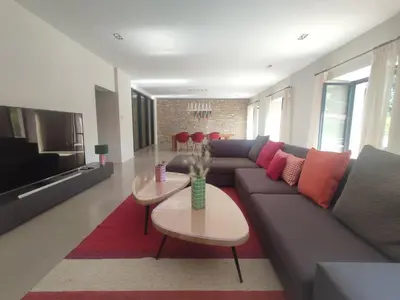 a living room with a couch and a table at Séjour d'exception au Moulin de la Vernède avec piscine, ruisseau, climatisation et parking in Conques-sur-Orbiel