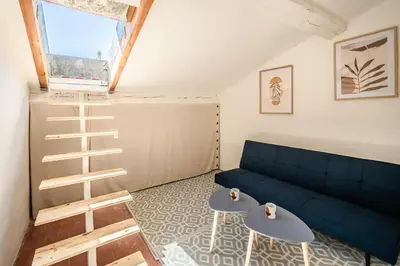 a living room with a blue couch and two tables at Narbonne Rooftop apt in Narbonne