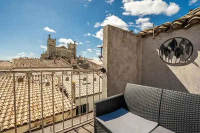 a balcony with a chair and a view of a castle at Narbonne Rooftop apt in Narbonne