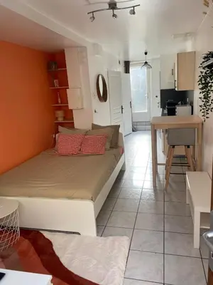 a bedroom with a bed and a kitchen with a table at Studio Cosy proche Cité Centre WiFi in Carcassonne