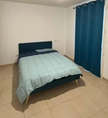 a bed with a blue comforter in a room at Villa Vinassan in Vinassan