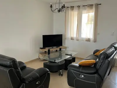 a living room with two chairs and a television at Villa Vinassan in Vinassan