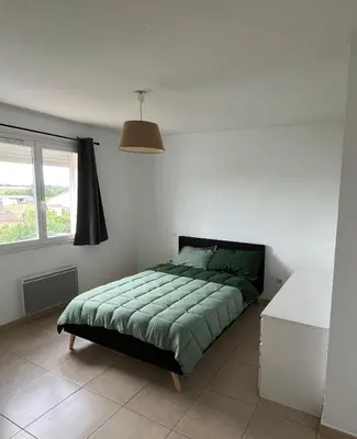 a bedroom with a bed with a green comforter at Villa Vinassan in Vinassan