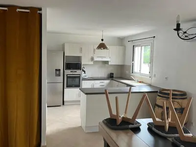 a kitchen with white cabinets and white appliances at Villa Vinassan in Vinassan
