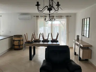 a dining room with a table with chairs and a chandelier at Villa Vinassan in Vinassan