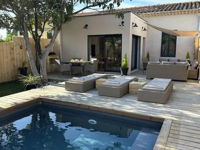 a backyard with a swimming pool and a patio with furniture at Le Gite Hector in Carcassonne