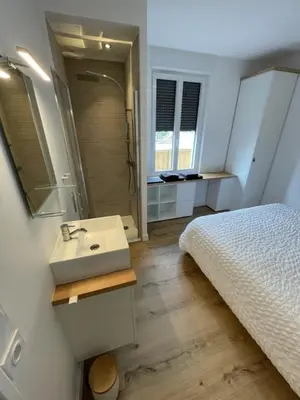 a bathroom with a bed and a sink and a mirror at Le Gite Hector in Carcassonne