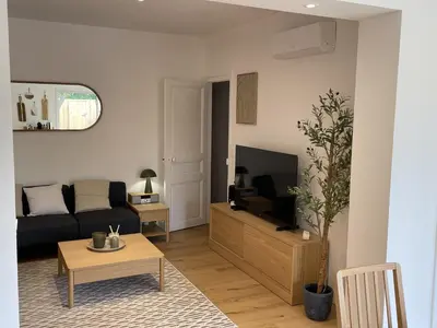 a living room with a couch and a tv at Le Gite Hector in Carcassonne