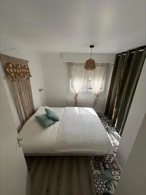 a bedroom with a large bed and two windows at Loni in Carcassonne