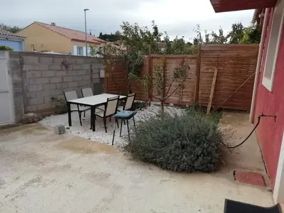 a backyard with a table and chairs and a fence at Charming house in a great location in Narbonne