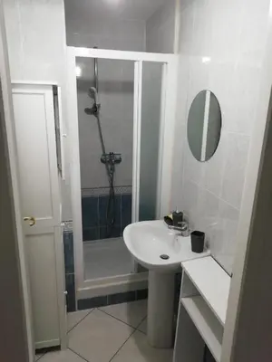 a white bathroom with a shower and a sink at Charming house in a great location in Narbonne