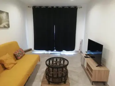 a living room with a couch and a television at Charming house in a great location in Narbonne