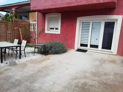 a red house with a table and chairs in front of it at Charming house in a great location in Narbonne