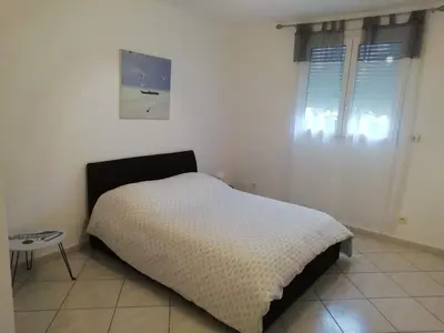 a bedroom with a bed and a table in it at Charming house in a great location in Narbonne