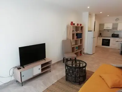 a living room with a flat screen tv on a white wall at Charming house in a great location in Narbonne