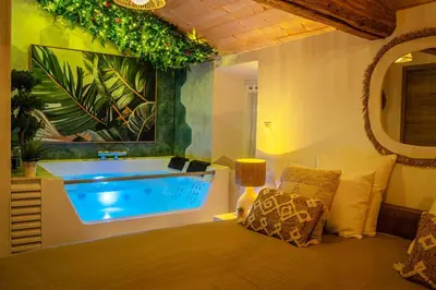 a bathroom with a tub and a chair in it at Loft & Spa Scandinave Romantique, King Size, TV 65 in Narbonne
