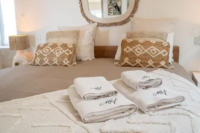 a bedroom with white towels on a bed with a mirror at Loft & Spa Scandinave Romantique, King Size, TV 65 in Narbonne