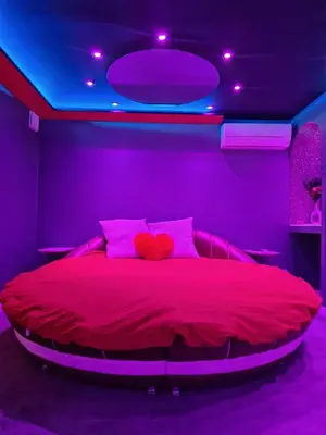 a bedroom with a large bed with purple lights at Secret Night Pamiers in Pamiers