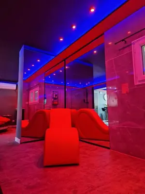 a red couch in a room with purple lights at Secret Night Pamiers in Pamiers